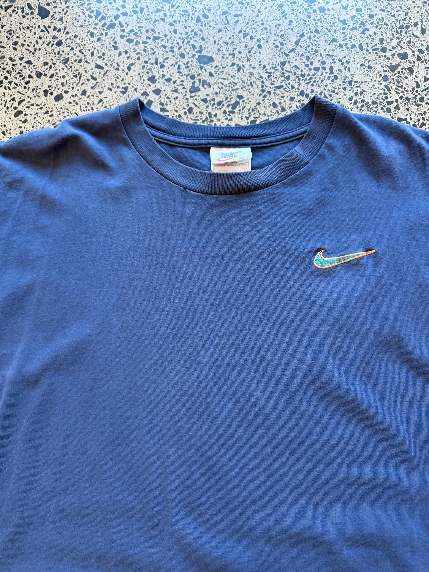 Vintage 90s Nike navy singlet with embroidered white swoosh logo. Size XL. Athletic streetwear.