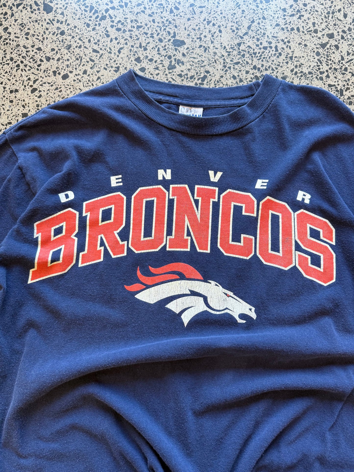 Vintage 90s NFL Denver Broncos navy t-shirt with bold orange and blue team graphic. Size XL. Football memorabilia.