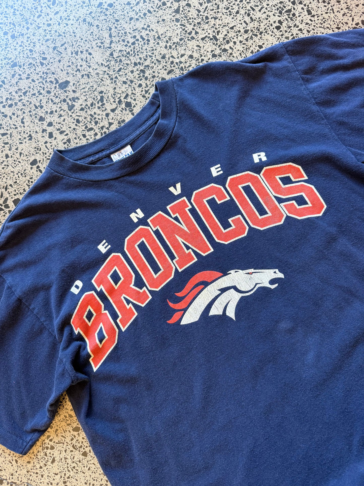 Vintage 90s NFL Denver Broncos navy t-shirt with bold orange and blue team graphic. Size XL. Football memorabilia.