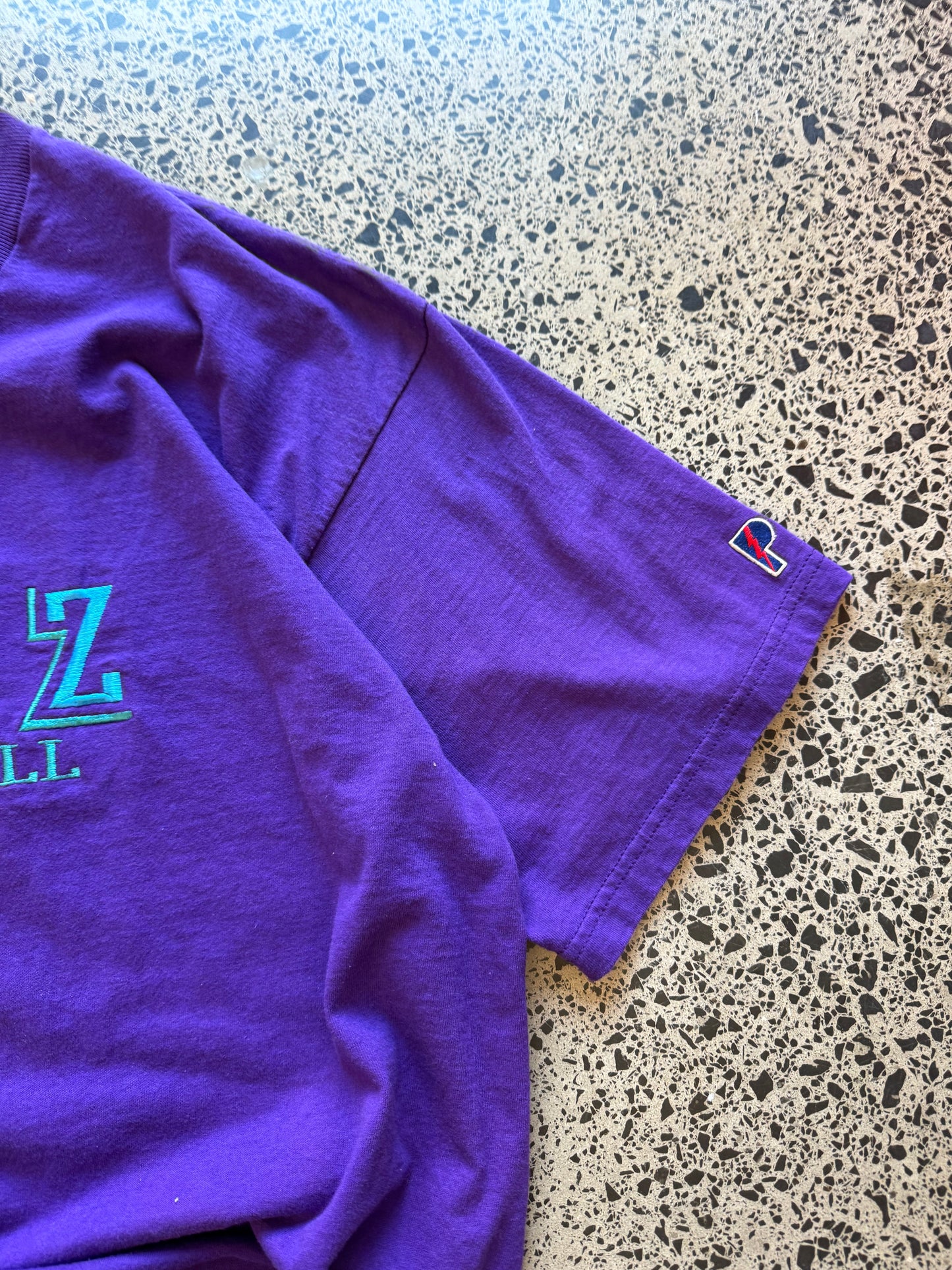 Vintage 90s Utah Jazz NBA t-shirt on a purple base and blue team logos and graphics embroidered across the front. Size 2XL. Oversized basketball streetwear