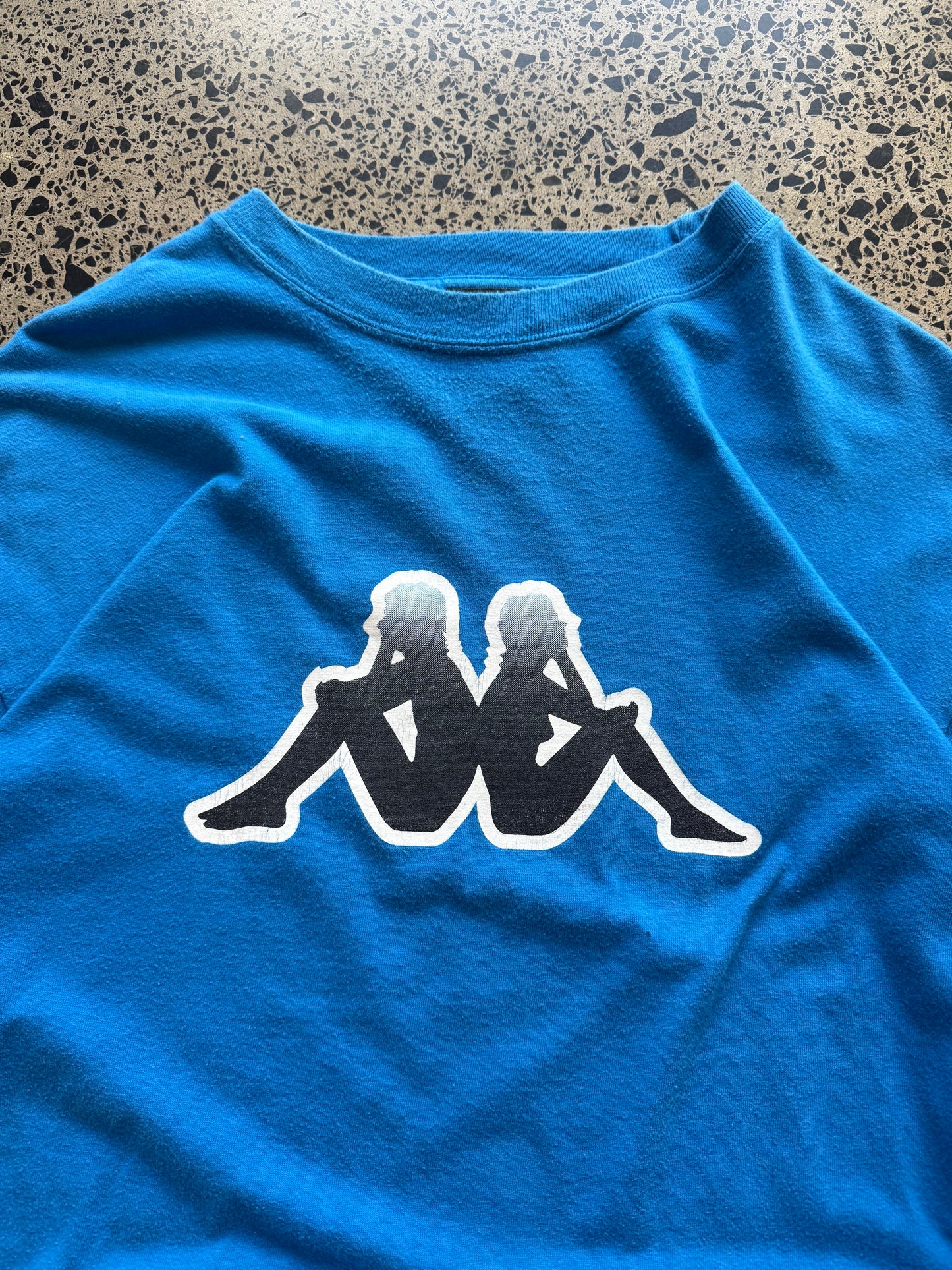 Blue Kappa t-shirt with large white logo graphic on front, size L, laid flat on white background