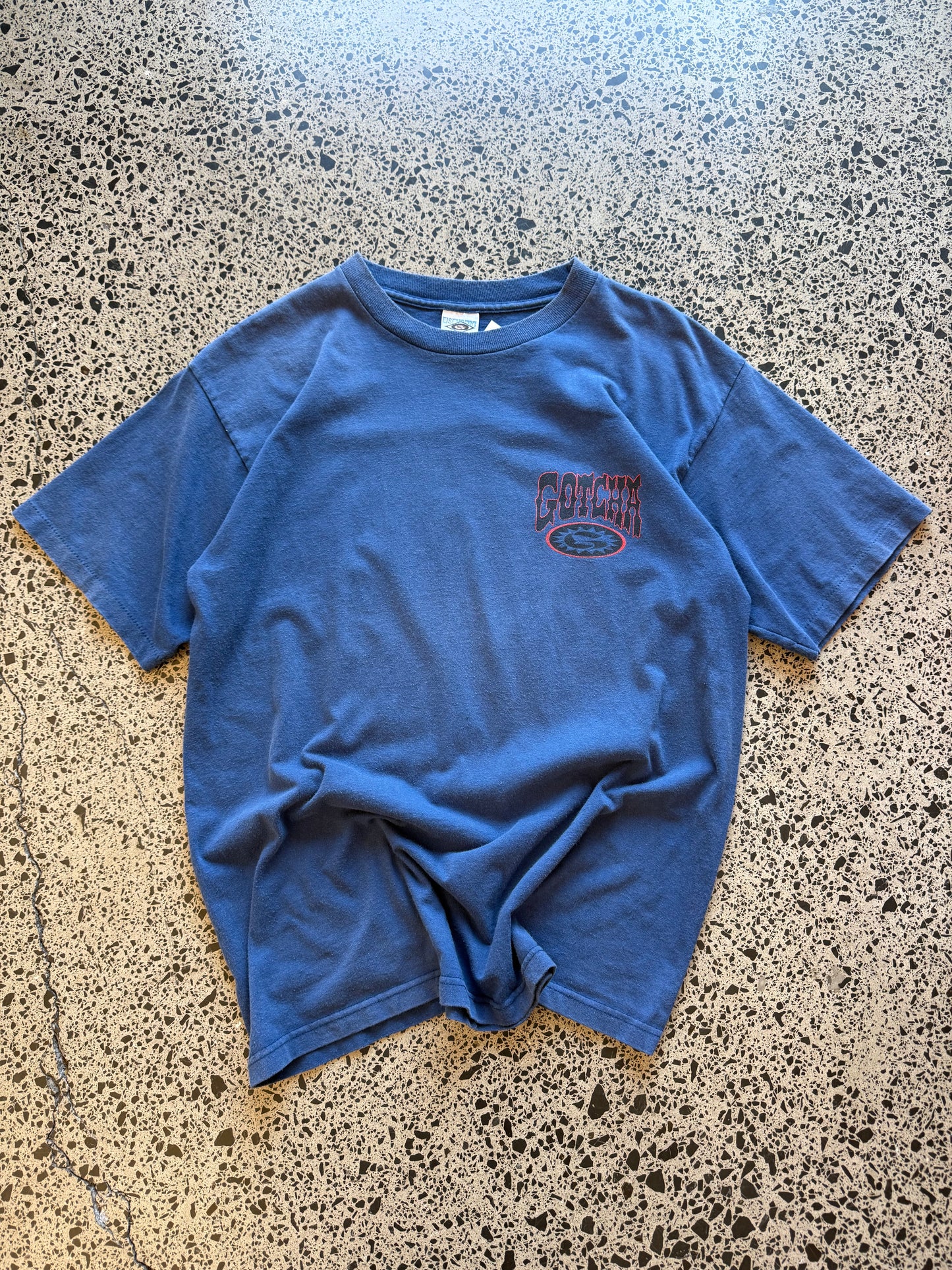 Vintage 90s Gotcha Surf blue t-shirt with bold colourful back graphic and subtle chest logo. Size L. Classic surfwear