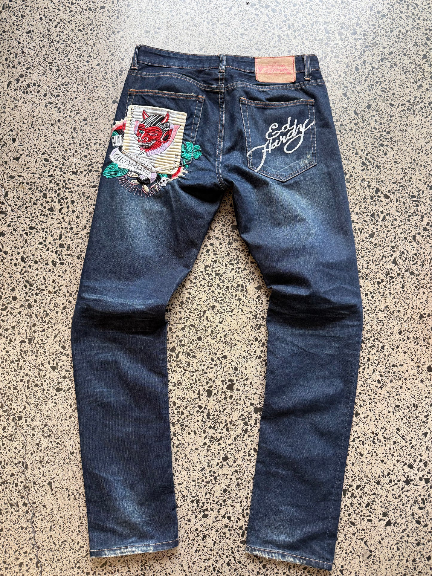 Y2K Ed Hardy embroidered dark blue jeans with devil joker playing card graphics. Size W32 L33.