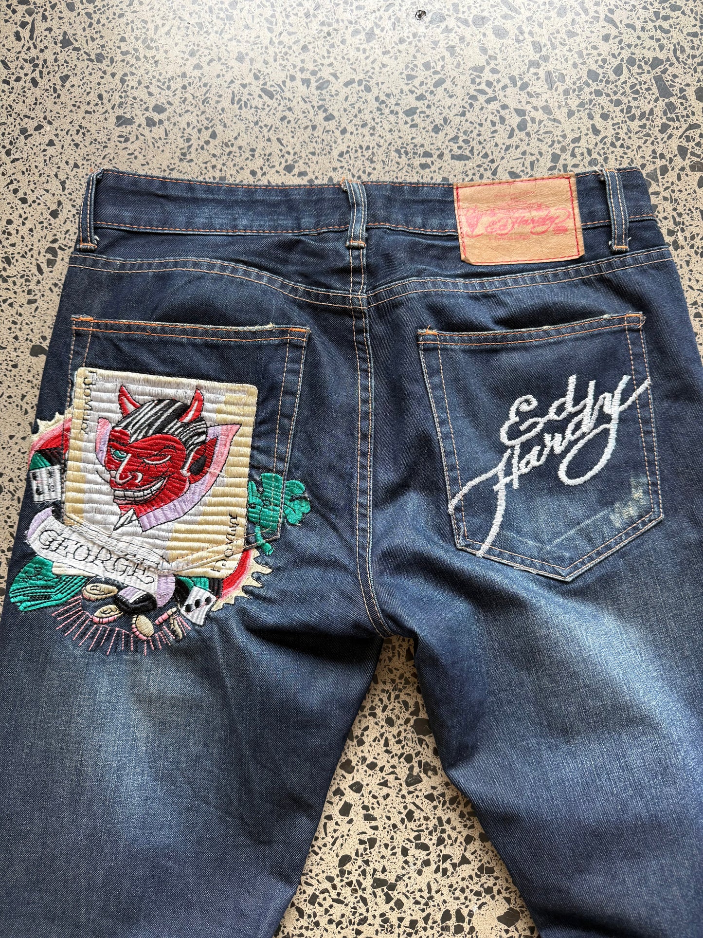 Y2K Ed Hardy embroidered dark blue jeans with devil joker playing card graphics. Size W32 L33.