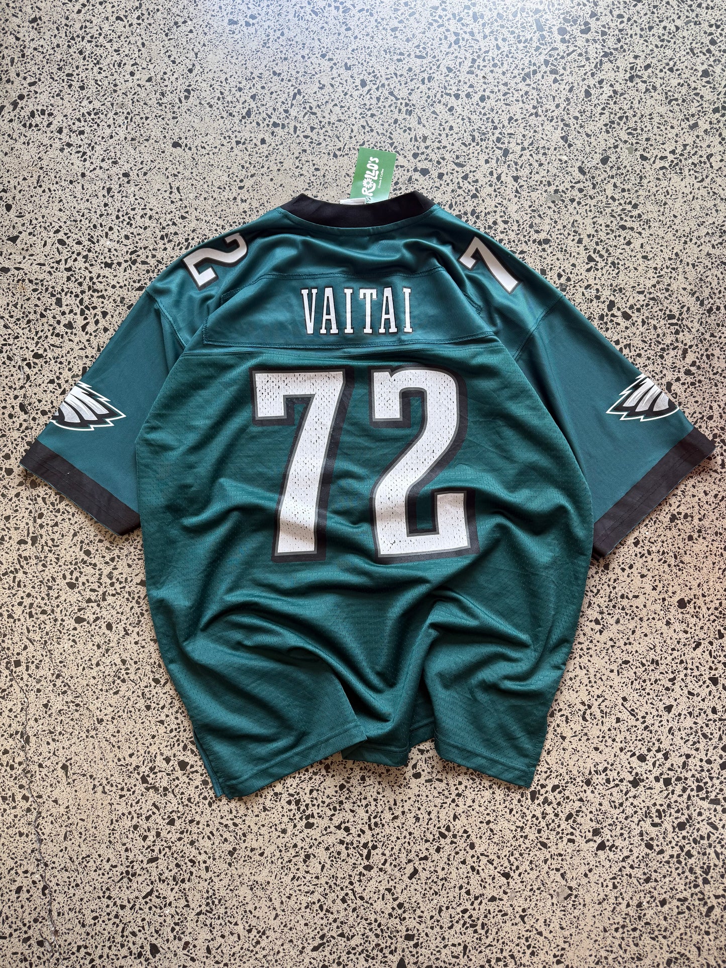 Philadelphia Eagles Halapoulivaati Vaitai NFL jersey size L laid on polished concrete background — midnight green with white detailing and Eagles logo.