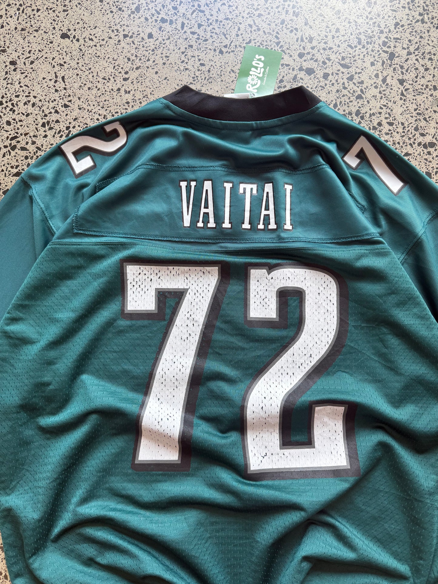 Philadelphia Eagles Halapoulivaati Vaitai NFL jersey size L laid on polished concrete background — midnight green with white detailing and Eagles logo.