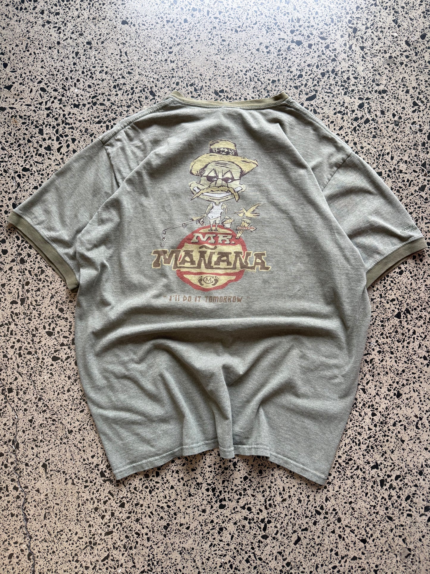 2001 Mr. Mañana graphic T-shirt, size L, laid on polished concrete background — bold early-2000s front print on soft cotton.