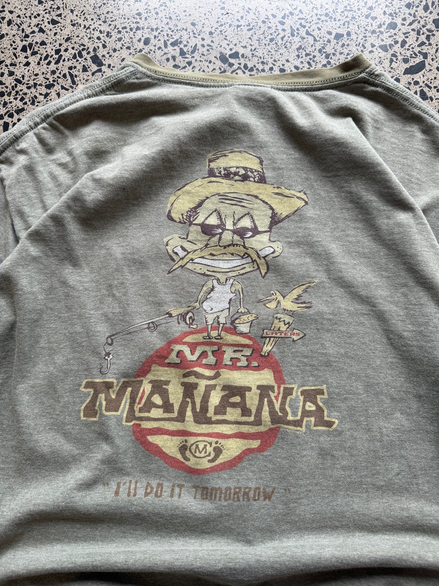 2001 Mr. Mañana graphic T-shirt, size L, laid on polished concrete background — bold early-2000s front print on soft cotton.