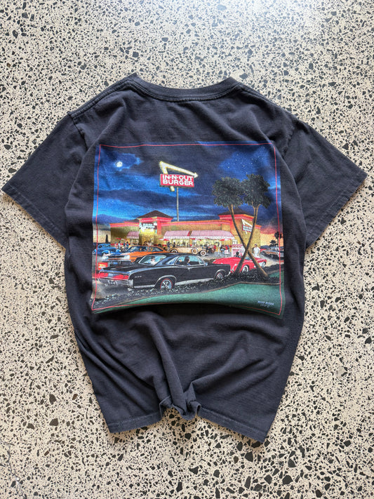 In-N-Out graphic T-shirt, size S, laid on polished concrete background — soft cotton with bold front logo print.