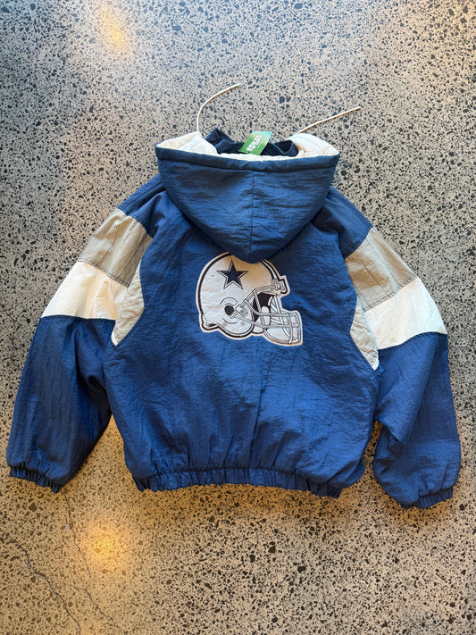 90s Dallas Cowboys Starter jacket size large laid flat on polished concrete background, vintage NFL jacket with bold team branding and classic Starter design