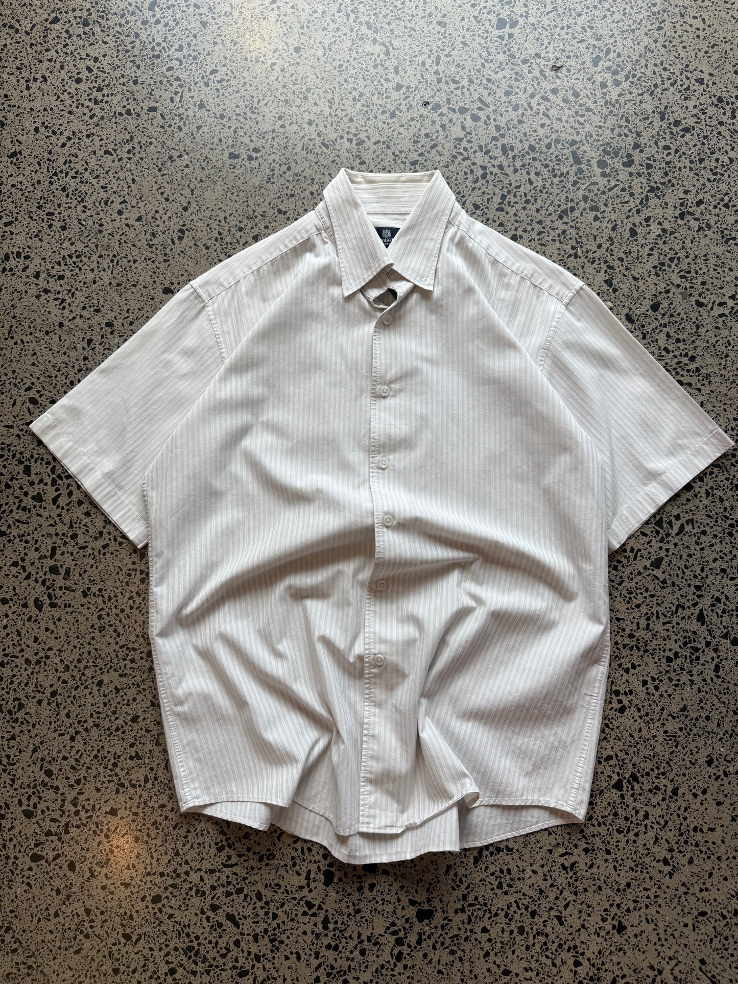 Aquascutum button-up shirt in size L laid flat on a polished concrete background featuring clean British heritage tailoring.