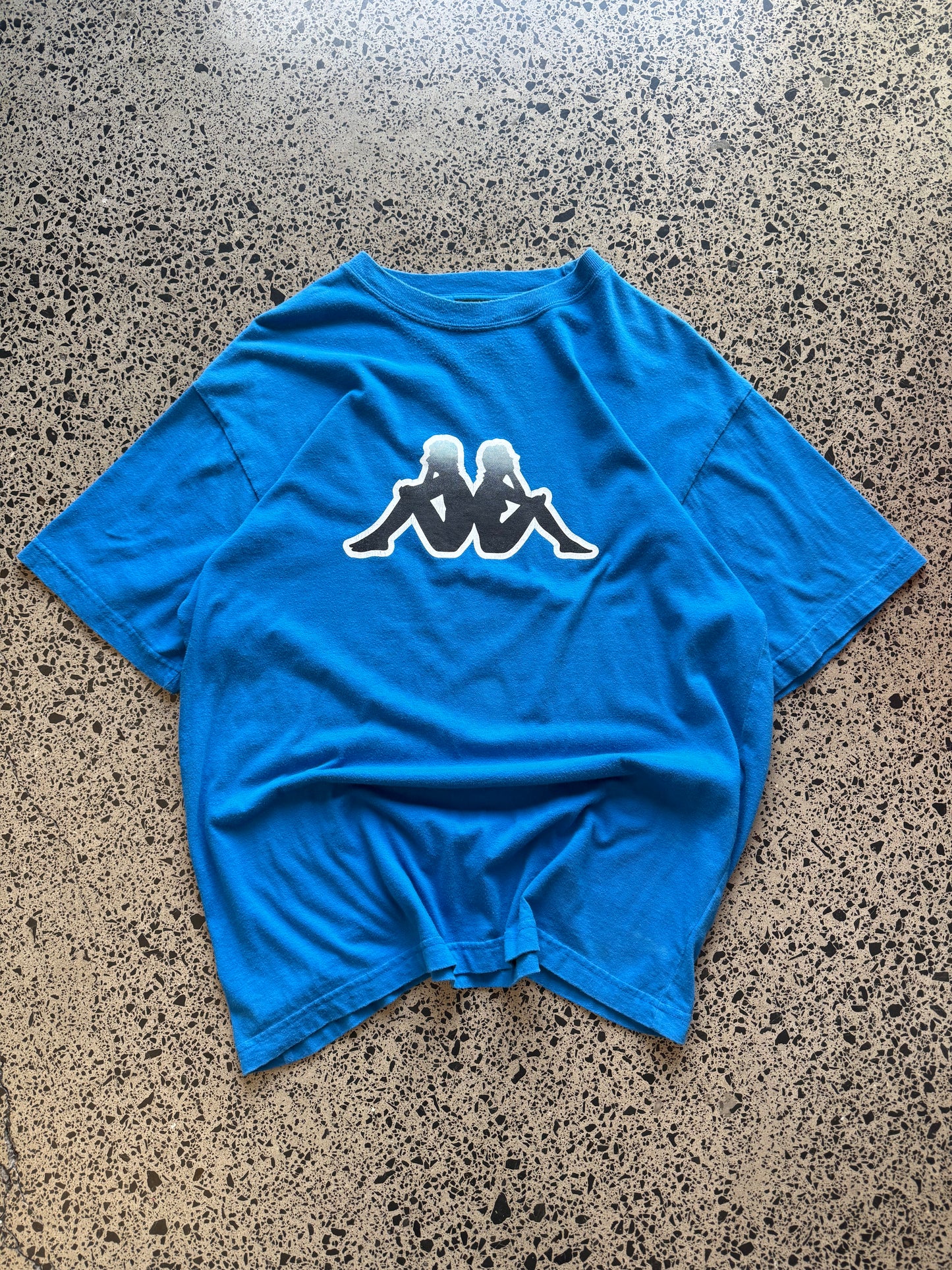 Blue Kappa t-shirt with large white logo graphic on front, size L, laid flat on white background