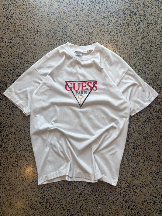 90s Guess embroidered logo T-shirt, size XL, laid on polished concrete background — vintage cotton tee with stitched Guess branding.