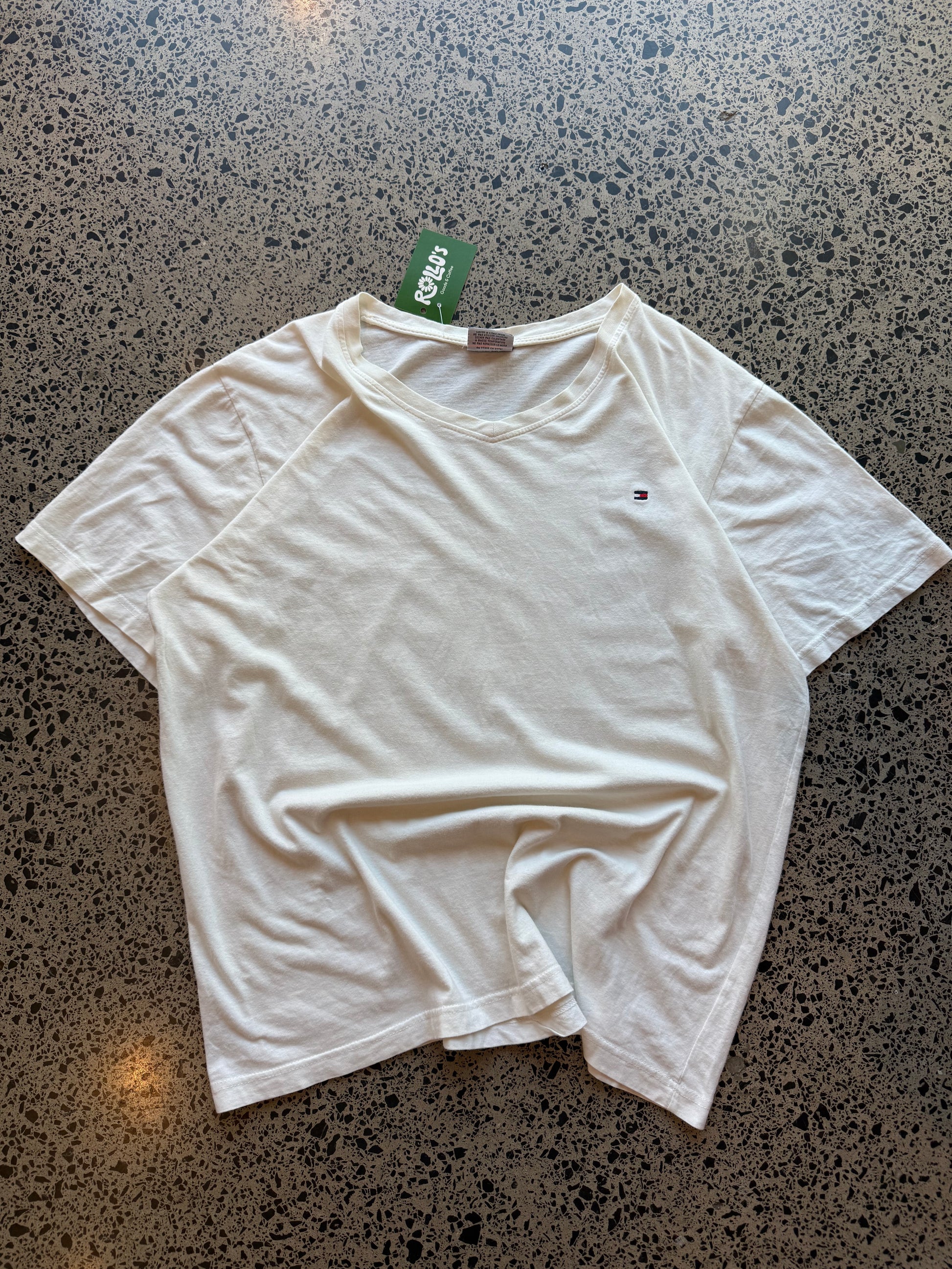 Tommy Hilfiger blank T-shirt, size 2XL, laid on polished concrete background — minimal design on soft cotton tee.