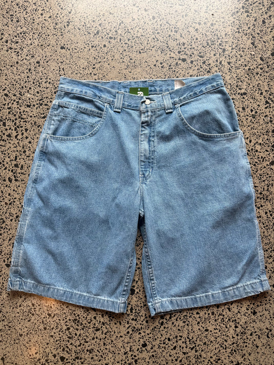 light blue wash denim jorts, size 34W, laid on polished concrete background. Knee cut with classic stitching and soft wash