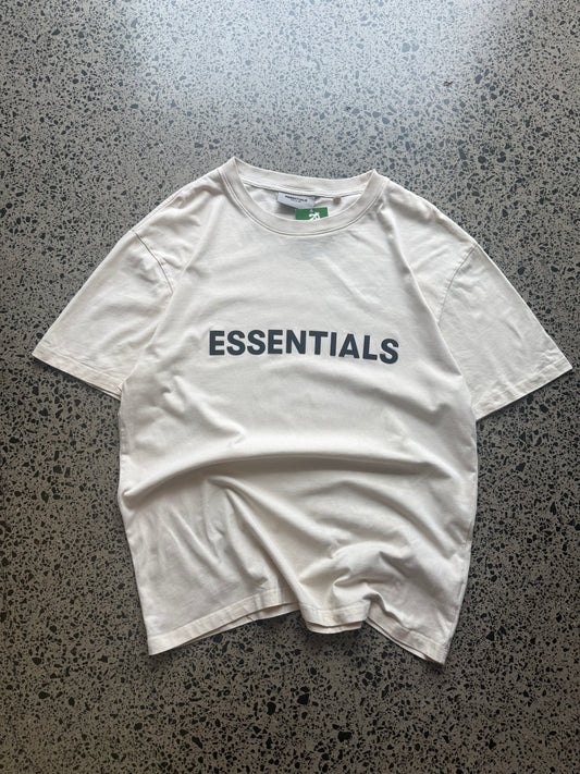 Fear of God Essentials t-shirt size M laid flat on polished concrete background, minimal streetwear tee with subtle Essentials branding and relaxed fit.