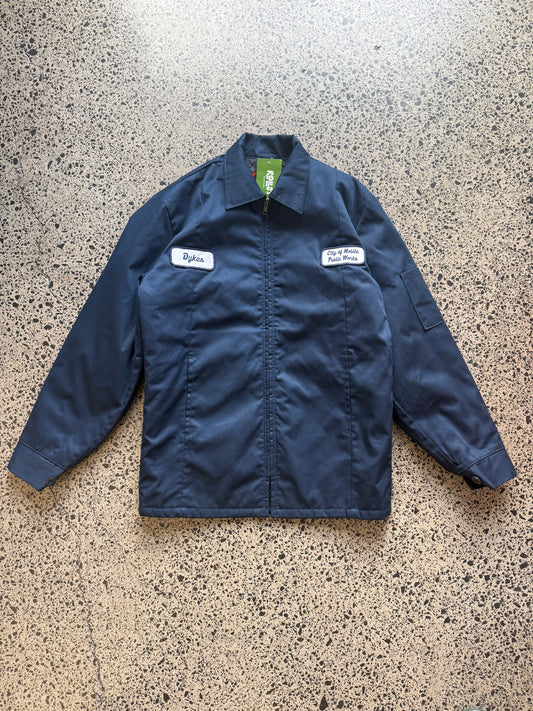 Red Kap workwear zipper jacket size Small Regular laid on polished concrete background — dark navy with zip front and pockets.