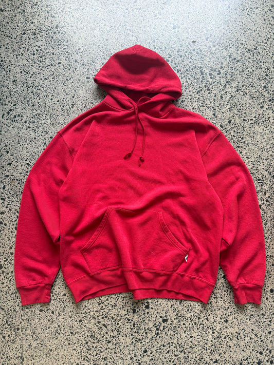 Russell Athletic blank hoodie size L laid on polished concrete background — red hoodie