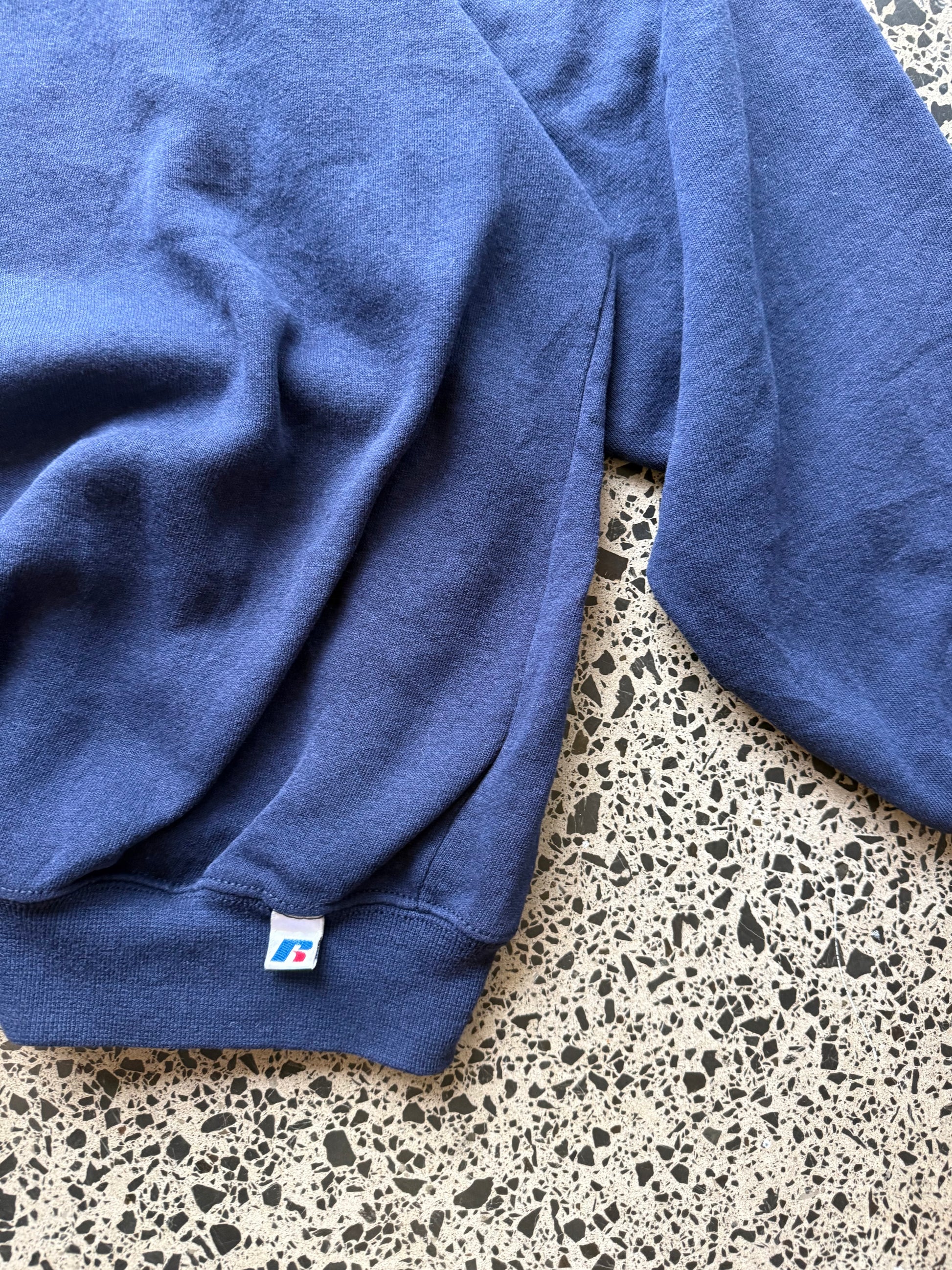90s University of Pittsburgh crewneck jumper size 3XL laid flat on polished concrete background, vintage college sweatshirt with bold lettering and oversized fit.