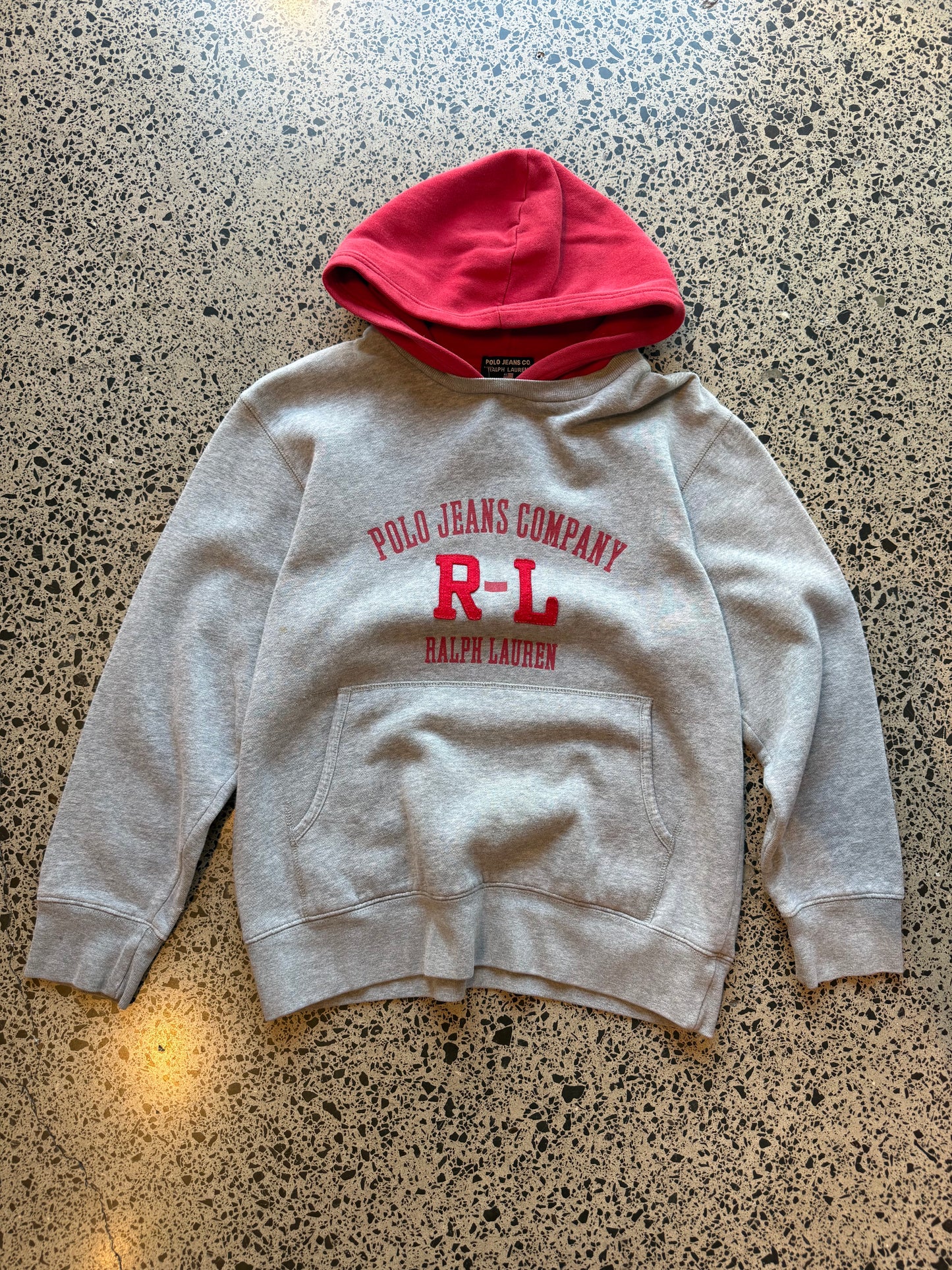 90s Ralph Lauren two-tone hoodie youth size L 10–12 laid flat on polished concrete background, vintage kids hoodie with colour block design and classic Ralph Lauren styling.