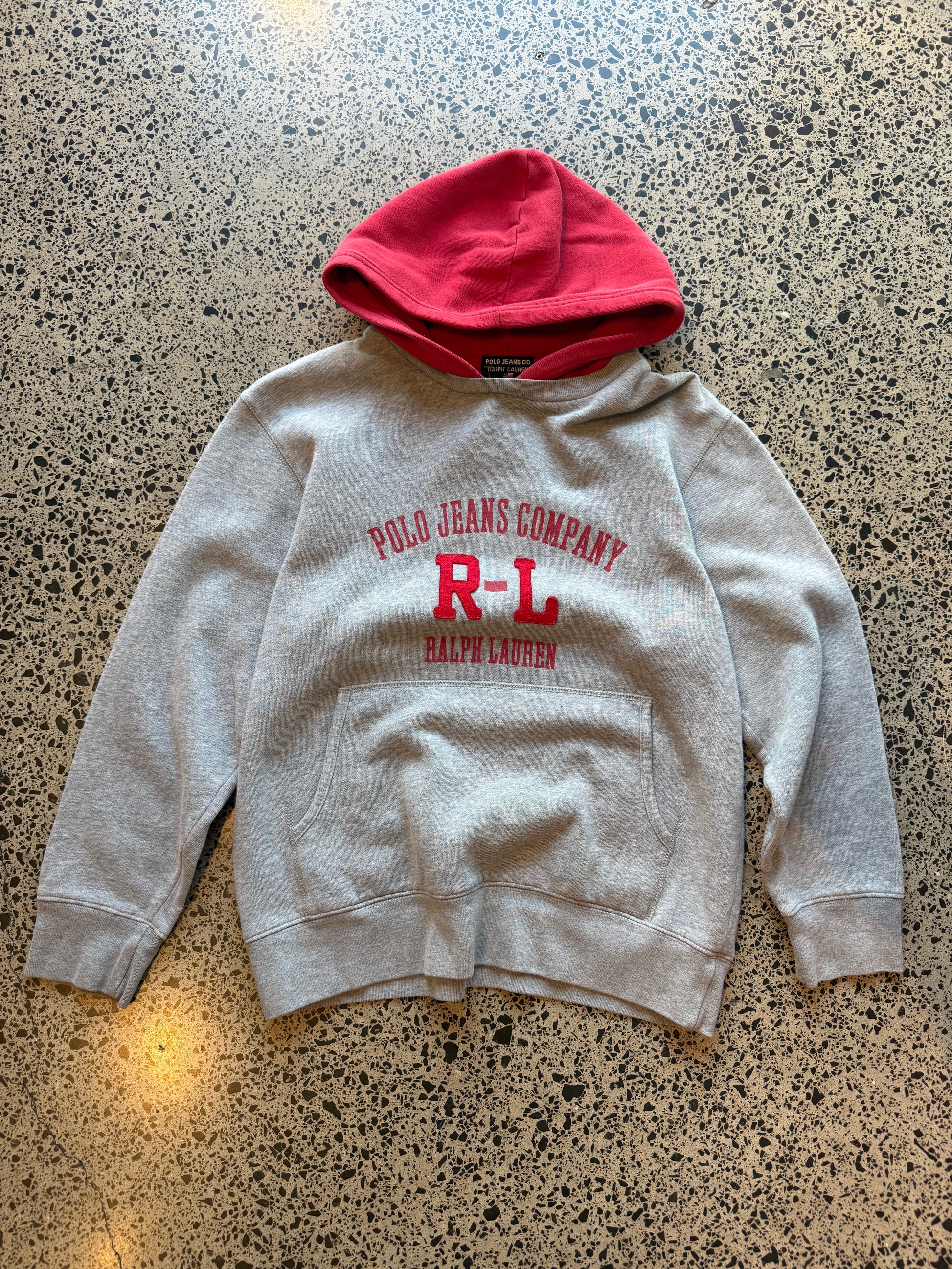 90s Ralph Lauren two-tone hoodie youth size L 10–12 laid flat on polished concrete background, vintage kids hoodie with colour block design and classic Ralph Lauren styling.