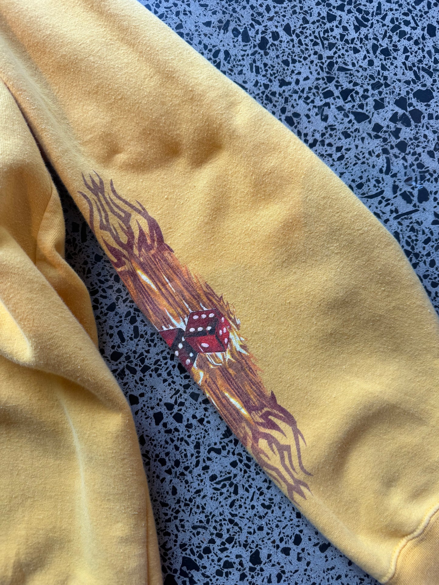 Y2K Top Heavy skull and bones hoodie XL laid flat on polished concrete background, vintage streetwear hoodie with bold graphic print and relaxed fit.