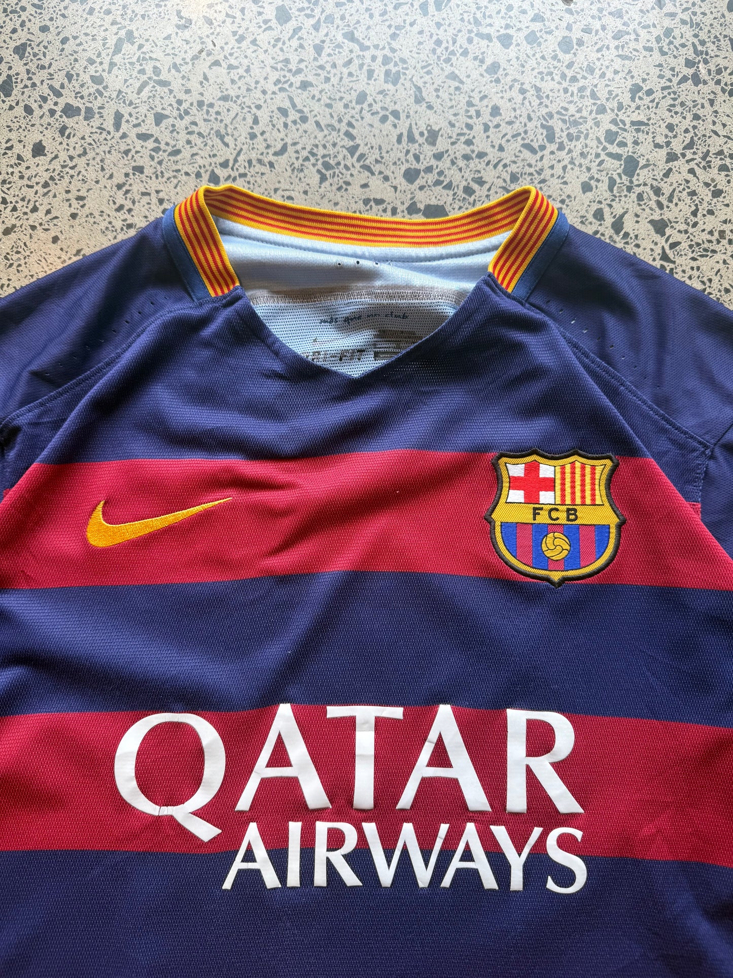 2015/16 FC Barcelona player issue football jersey in size L laid flat on a polished concrete background featuring the classic blue and red stripes.