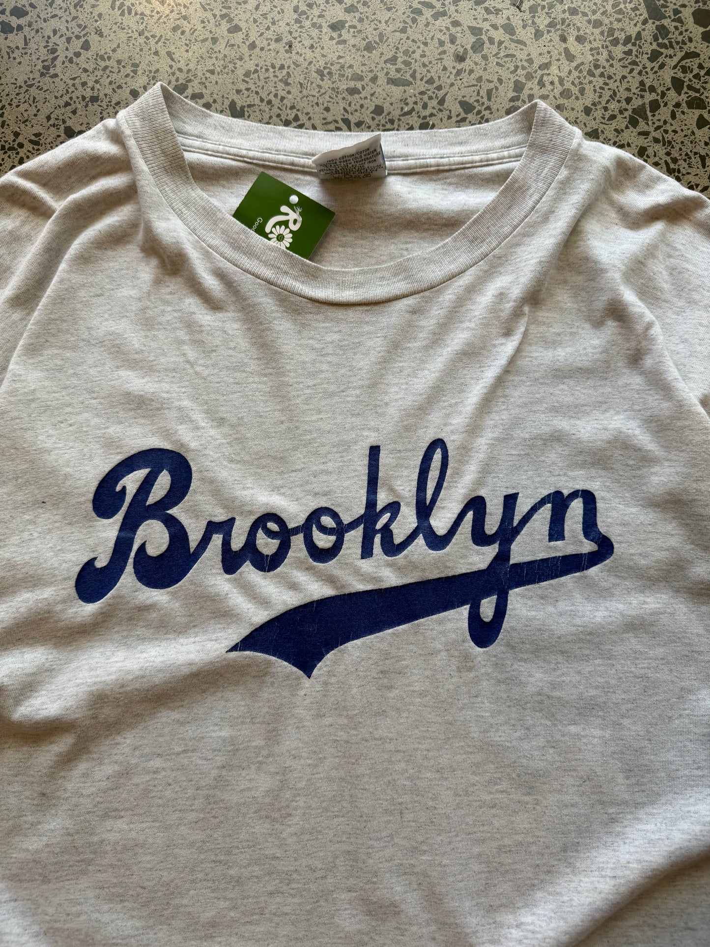 90s grey Brooklyn graphic T-shirt, size 2XL, laid on polished concrete background soft vintage cotton with bold NYC lettering.