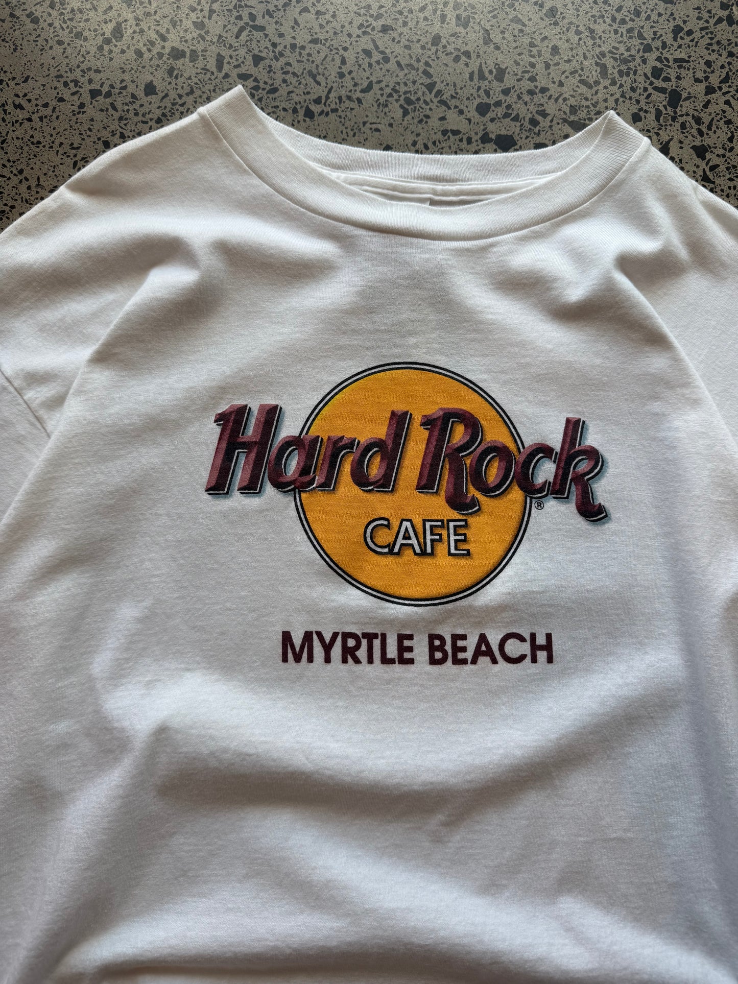 90s Myrtle Beach Hard Rock T-shirt, size XL, laid on polished concrete background vintage Hard Rock logo on soft 90s cotton.