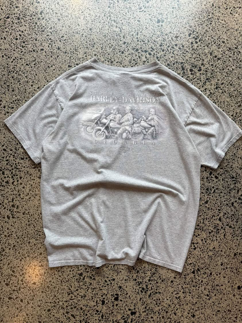 Harley-Davidson graphic T-shirt in size L laid flat on a polished concrete background featuring bold motorcycle-inspired branding