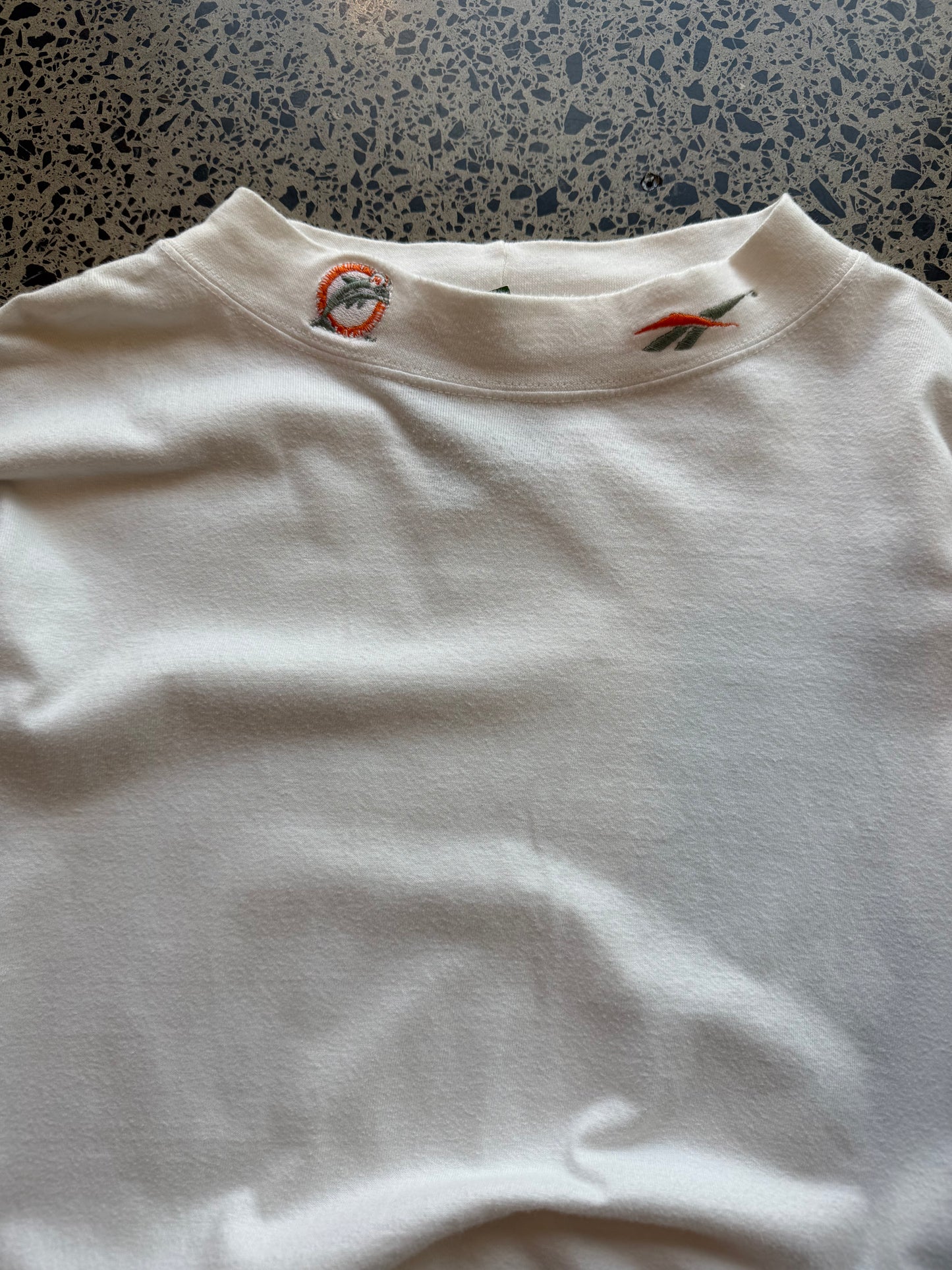 90s Miami Dolphins NFL long sleeve shirt 2XL laid flat on polished concrete background, vintage football tee with team colors and bold graphics.