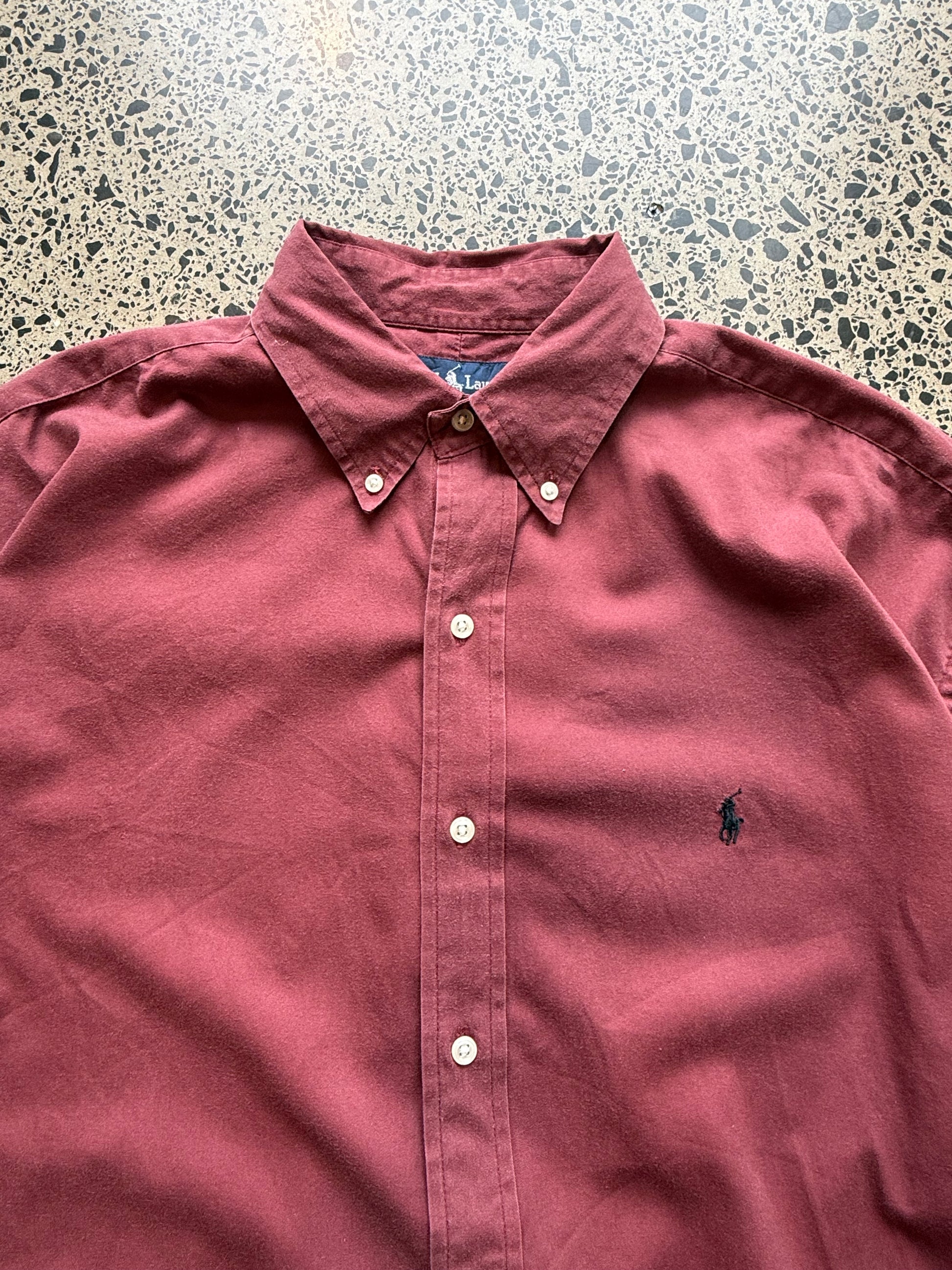 Ralph Lauren button-up shirt size XL laid flat on polished concrete background, classic designer shirt with clean styling and relaxed fit.