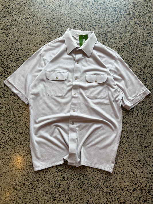 Late 80s early 90s Dior button-up shirt in size L laid flat on a polished concrete background featuring classic vintage designer tailoring.