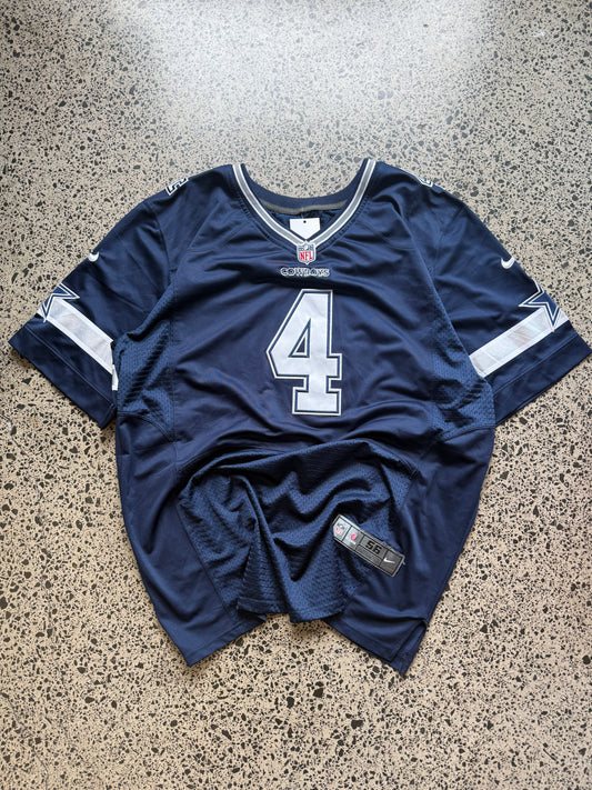 Dallas Cowboys Dak Prescott NFL jersey size 3XL laid on polished concrete background — navy with white detailing and star logo.