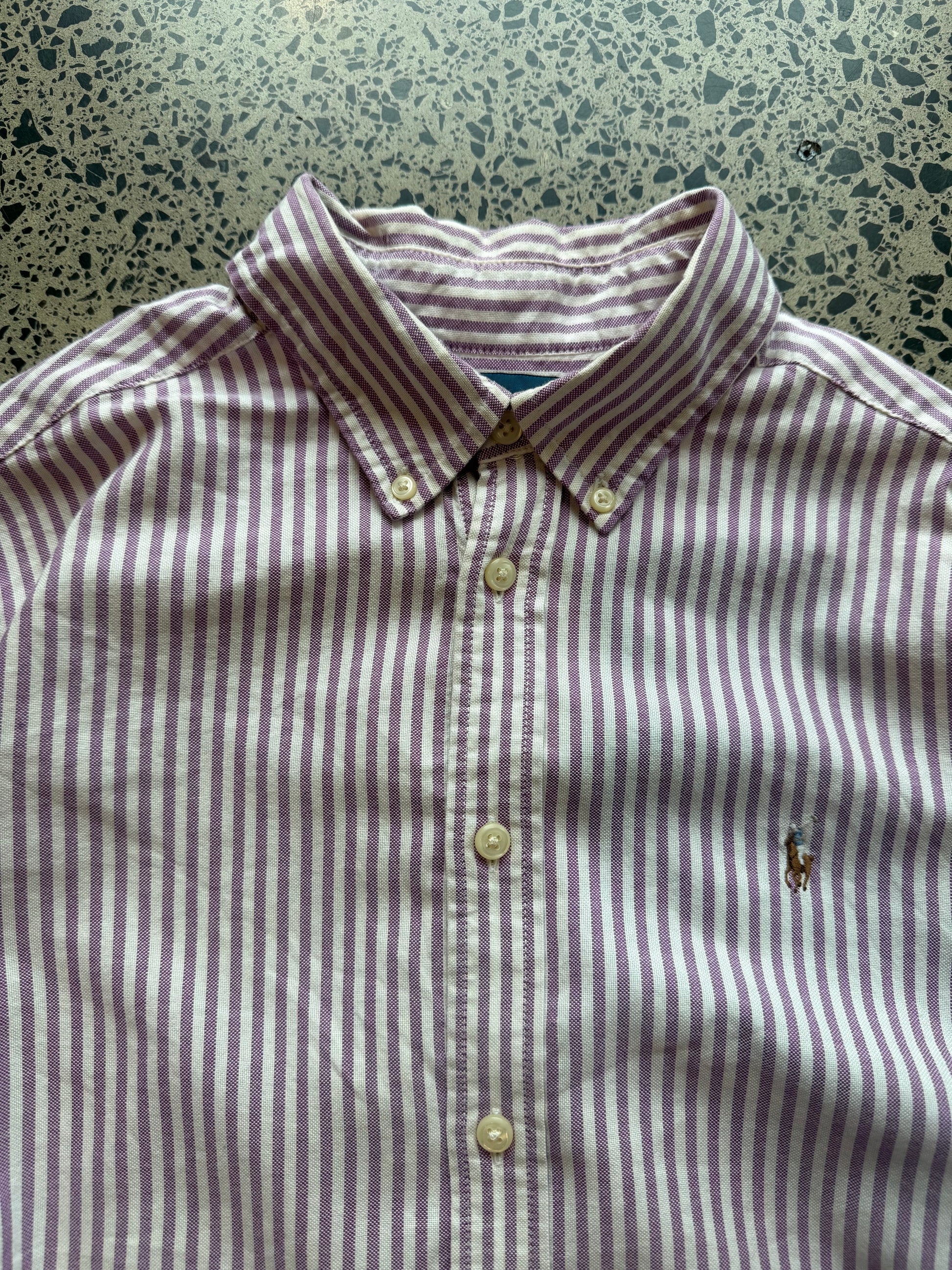 Pinstripe Ralph Lauren button-up shirt size L laid flat on polished concrete background, classic designer shirt with subtle stripe pattern and relaxed fit.