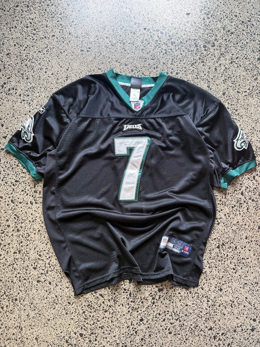 Philadelphia Eagles Michael Vick NFL jersey size 2XL laid on polished concrete background — midnight green with white detailing and Eagles logo.