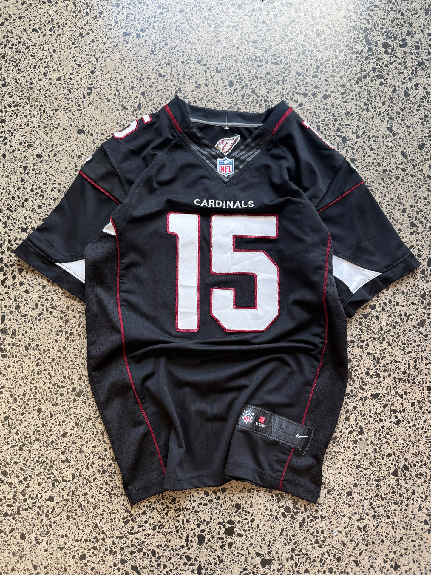 Arizona Cardinals Michael Floyd NFL jersey size L laid on polished concrete background — red with white detailing and Cardinals logo.