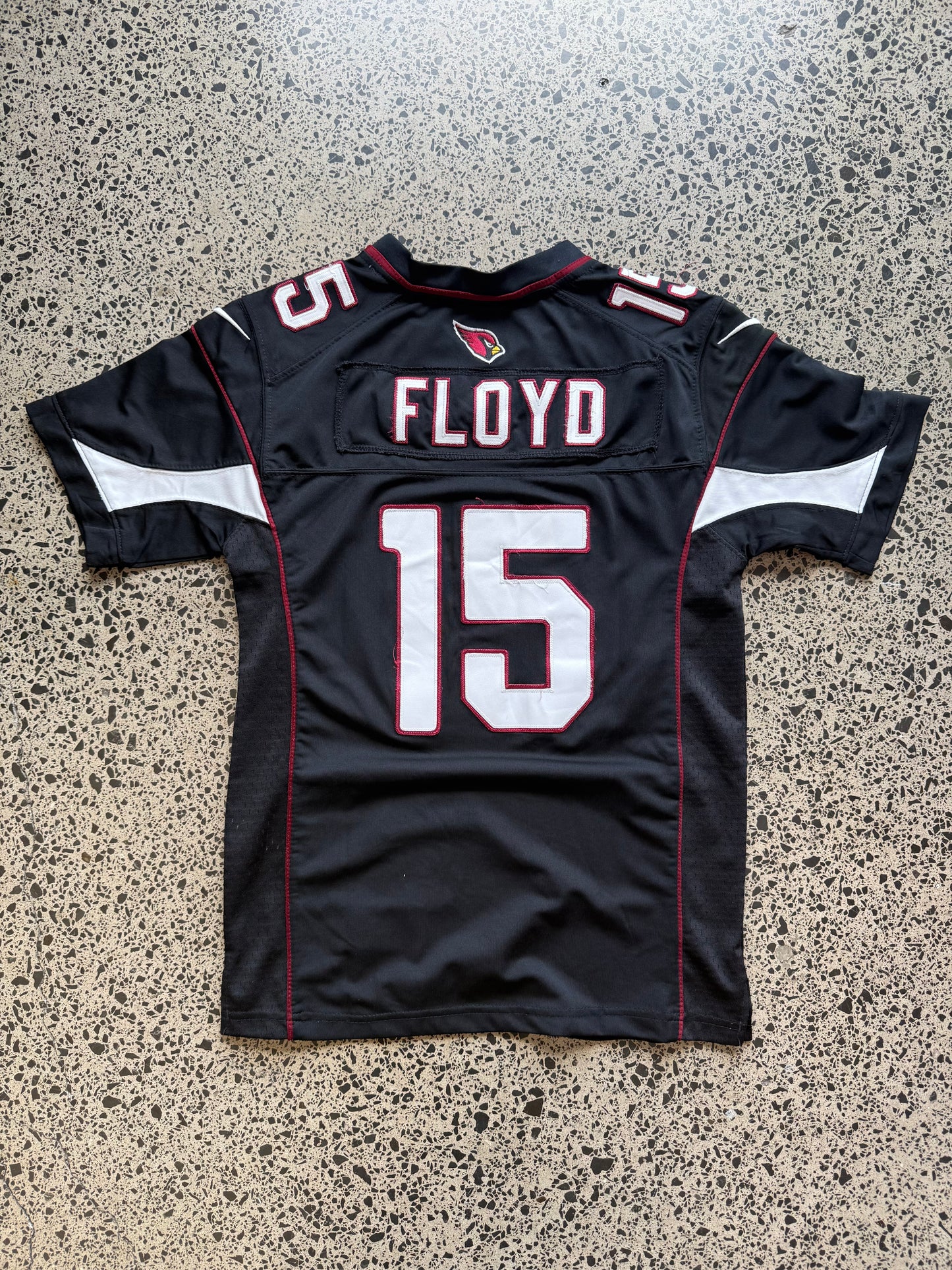 Arizona Cardinals Michael Floyd NFL jersey size L laid on polished concrete background — red with white detailing and Cardinals logo.