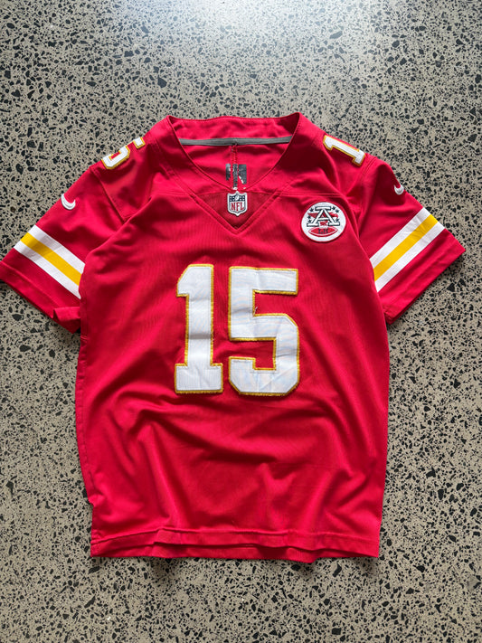 Kansas City Chiefs Patrick Mahomes NFL jersey in Youth Large laid on polished concrete background — red with white and yellow detailing and Chiefs logo.