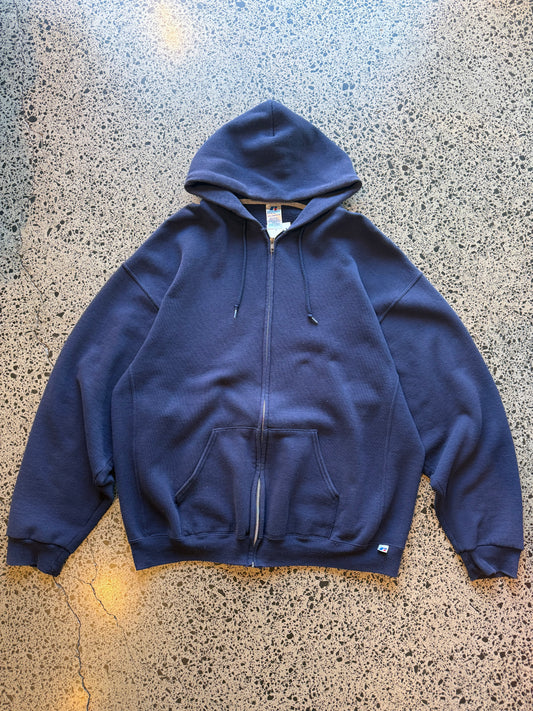 2010s Russell Athletic blank zip-up hoodie size 2XL laid flat on polished concrete background, minimal vintage hoodie with no graphics and relaxed oversized fit.