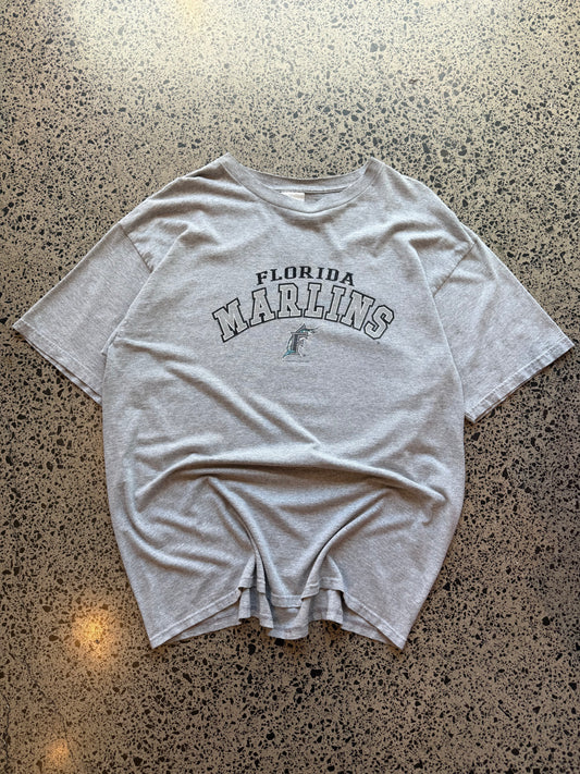 2004 Florida Marlins baseball T-shirt, size 2XL, laid on polished concrete background with early-2000s MLB graphic.