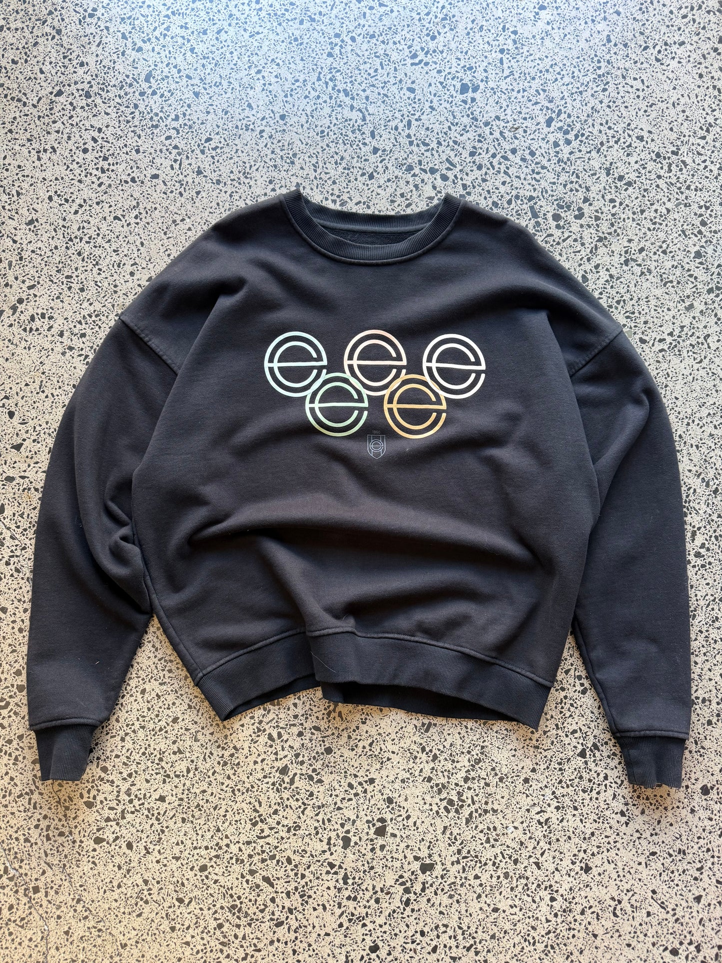 Earl’s Collection graphic crewneck size L laid flat on polished concrete background, streetwear sweatshirt with bold front graphic and relaxed fit.