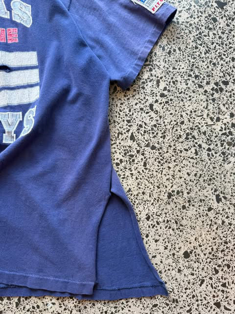 1993 Dallas Cowboys NFL T-shirt in size XL laid on a polished concrete background — vintage early-90s football graphic on soft cotton.