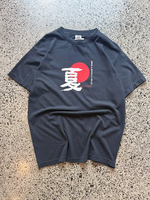 Early 2000s San Francisco Chinatown graphic T-shirt laid on a polished concrete background featuring a souvenir-style city graphic.