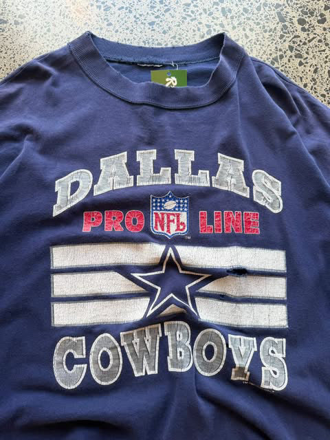 1993 Dallas Cowboys NFL T-shirt in size XL laid on a polished concrete background — vintage early-90s football graphic on soft cotton.