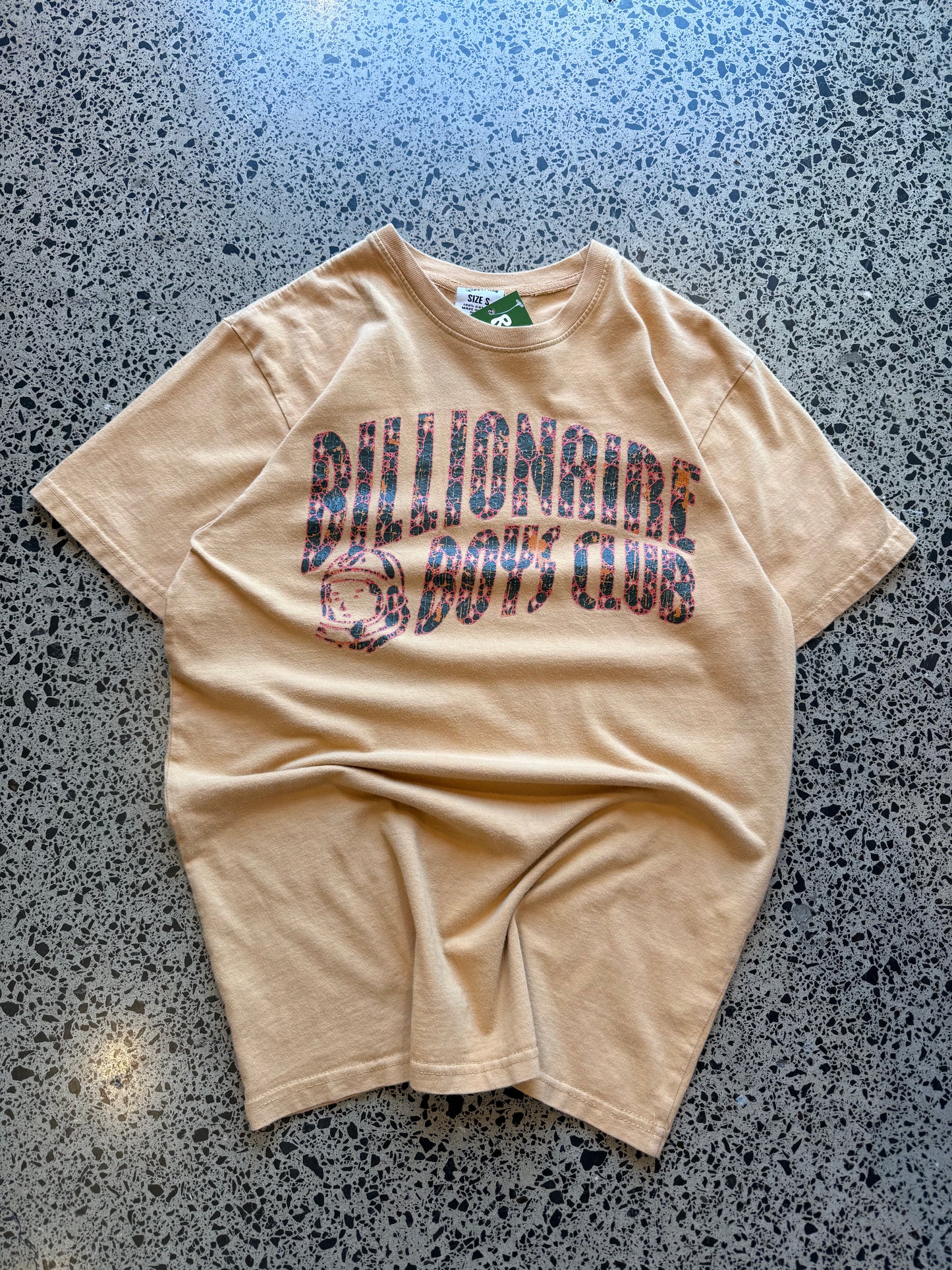 2022 Billionaire Boys Club tan logo T-shirt, size L, laid on polished concrete background — soft cotton with bold chest print.