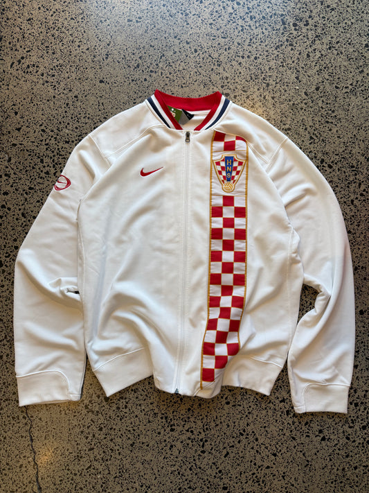 Croatia Nike red and white zip-up football jumper, size XXL, laid on polished concrete background — ¼-zip pullover with team crest and swoosh.