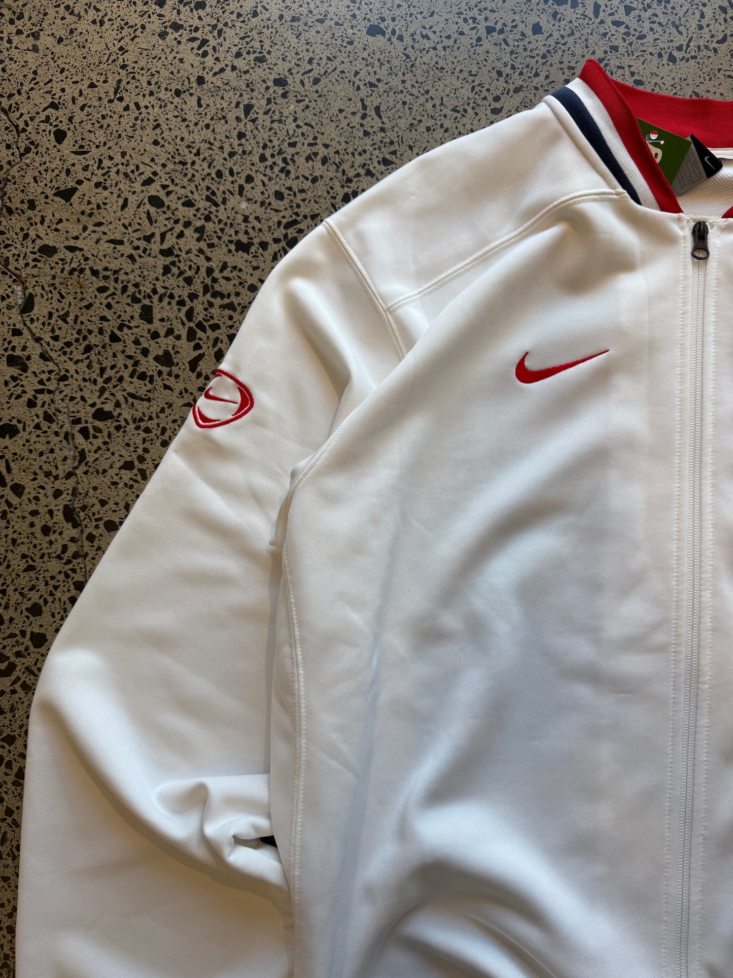 Croatia Nike red and white zip-up football jumper, size XXL, laid on polished concrete background — ¼-zip pullover with team crest and swoosh.